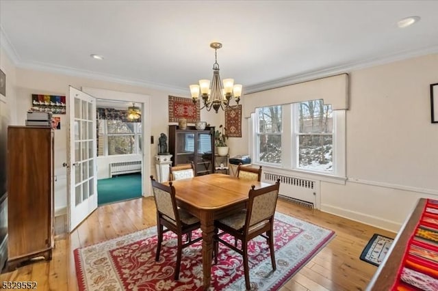 dining room featuring hardwood / wood-style floors, crown molding, and radiator heating unit