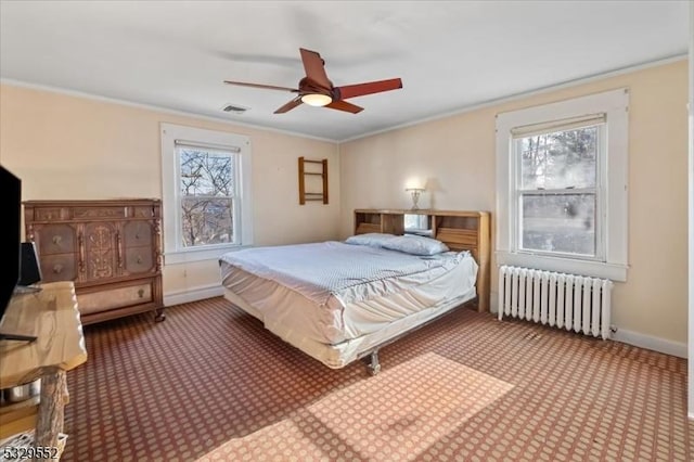 carpeted bedroom featuring multiple windows, crown molding, radiator heating unit, and ceiling fan