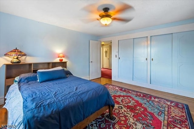 bedroom with multiple closets, ceiling fan, and hardwood / wood-style floors