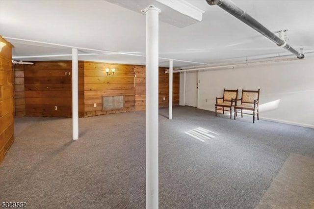 basement featuring carpet floors and wooden walls