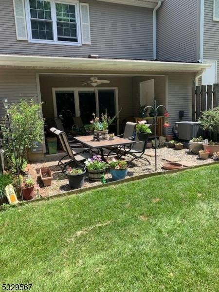 back of house featuring a patio area, ceiling fan, a lawn, and cooling unit