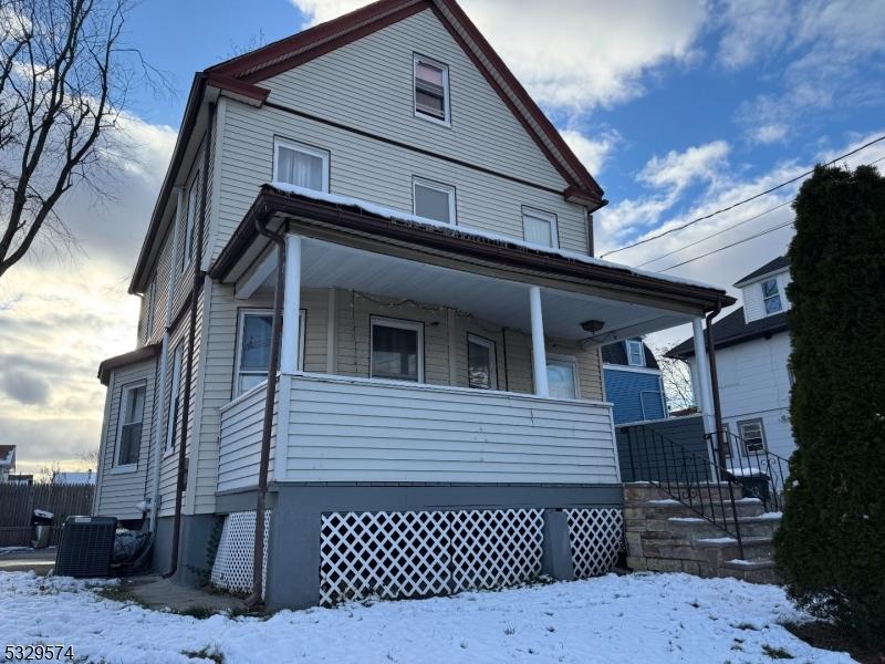 view of front of property with a porch and central air condition unit