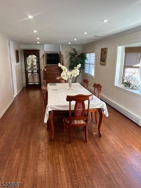 dining space featuring dark hardwood / wood-style floors and ornamental molding