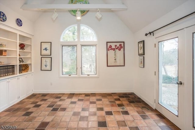 interior space with vaulted ceiling with beams, a healthy amount of sunlight, and french doors