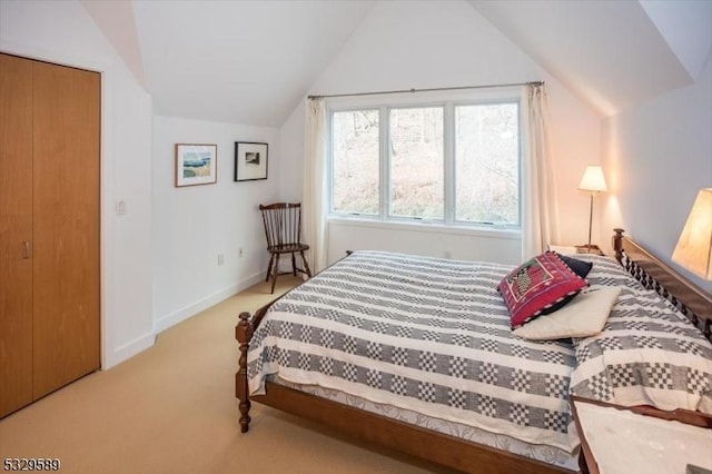 bedroom featuring light carpet, a closet, and vaulted ceiling