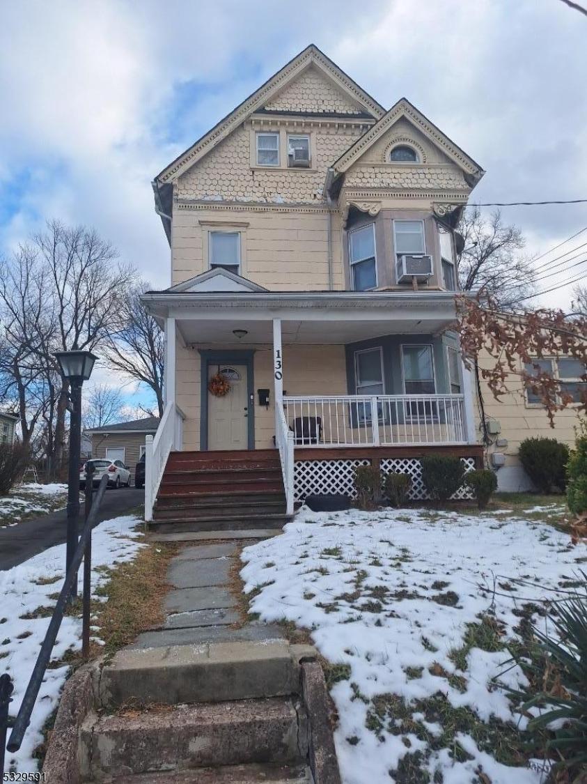 victorian-style house with a porch and cooling unit