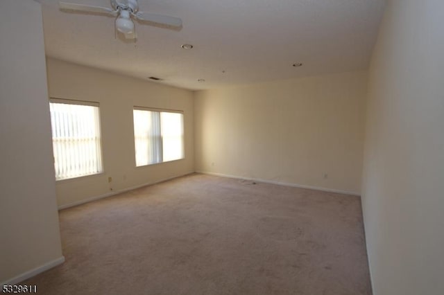 carpeted spare room with ceiling fan