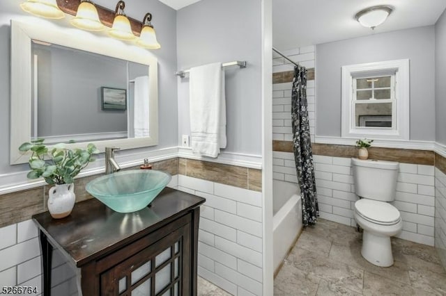 full bathroom featuring vanity, toilet, shower / bathtub combination with curtain, and tile walls