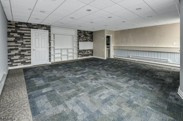 interior space with dark colored carpet and a paneled ceiling