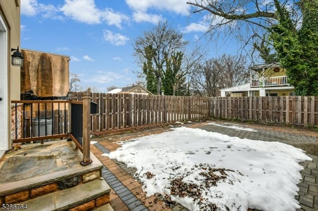 yard layered in snow with a patio