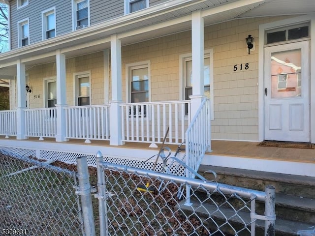 view of exterior entry featuring covered porch