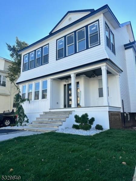 view of front of property with covered porch and a front lawn