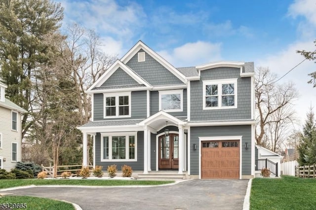 view of front of house with an attached garage, fence, aphalt driveway, and french doors