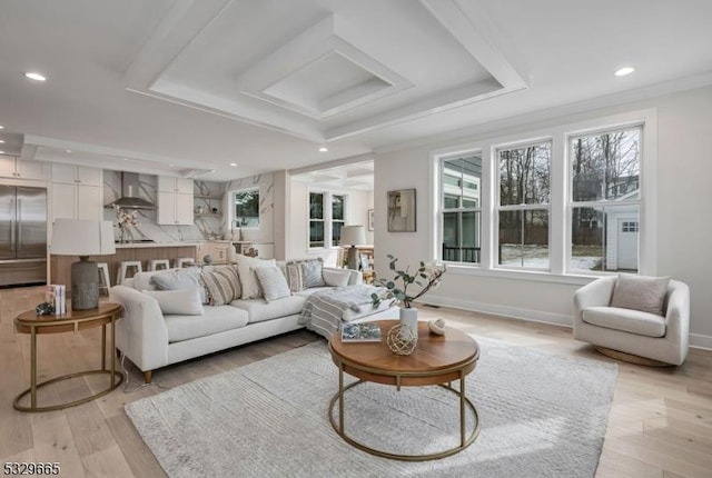 living room featuring light wood-style flooring, a tray ceiling, baseboards, and recessed lighting