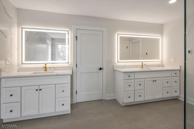 bathroom featuring two vanities, a sink, and tile patterned floors