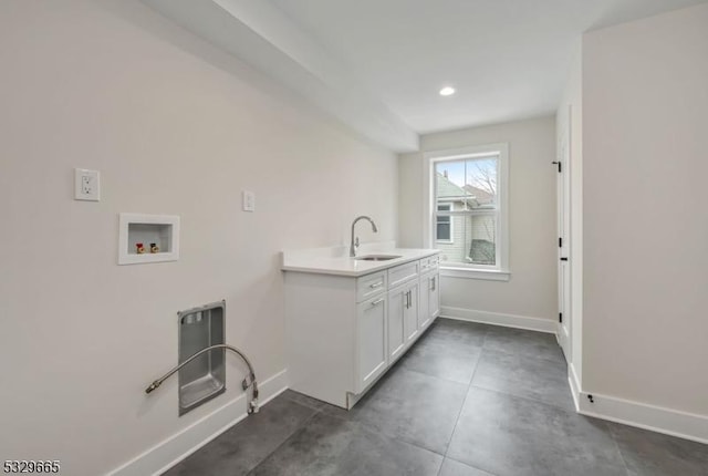 washroom with hookup for a washing machine, recessed lighting, cabinet space, a sink, and baseboards