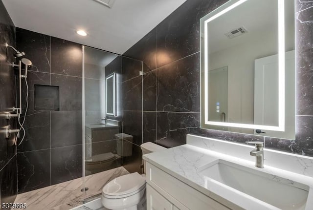 bathroom with tile walls, visible vents, toilet, vanity, and a walk in shower