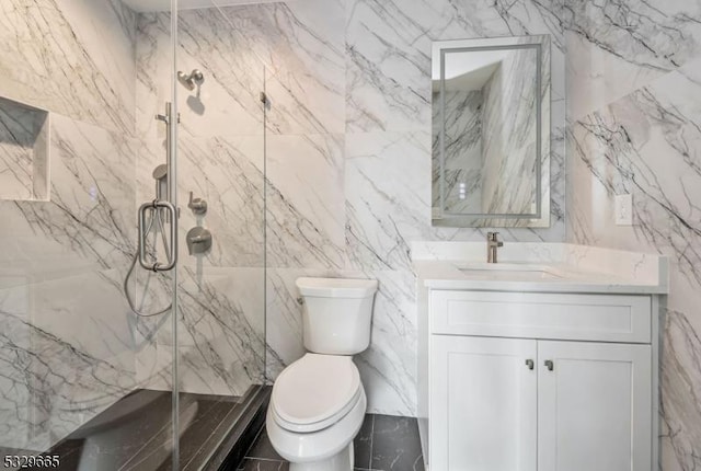 full bathroom with vanity, a marble finish shower, toilet, and tile walls