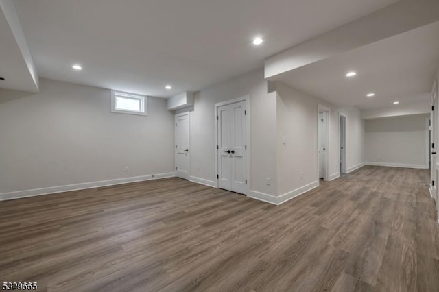 below grade area featuring recessed lighting, wood finished floors, and baseboards