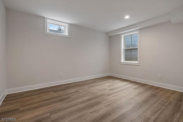 below grade area featuring dark wood-type flooring, recessed lighting, and baseboards