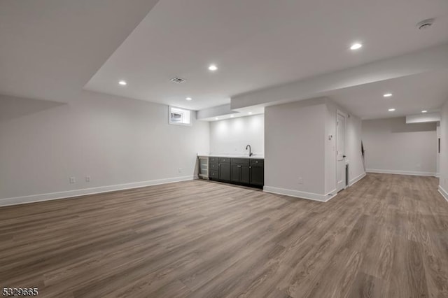 basement featuring recessed lighting, visible vents, baseboards, and wood finished floors