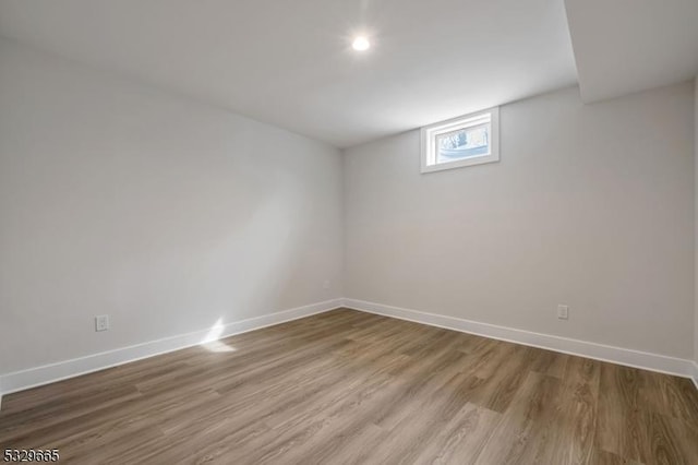 basement with baseboards and wood finished floors