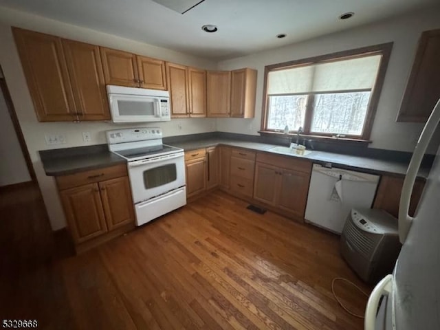 kitchen with sink, dark hardwood / wood-style floors, and white appliances