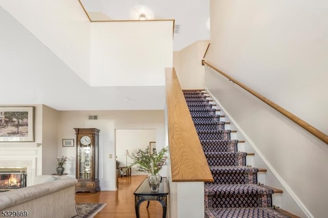 stairway featuring wood-type flooring and a high ceiling