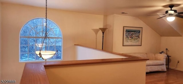 stairs with lofted ceiling, hardwood / wood-style floors, and ceiling fan