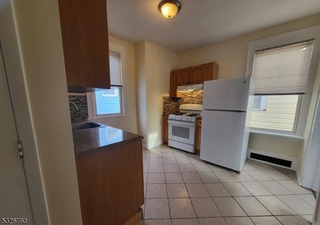 kitchen featuring light tile patterned floors, white appliances, tasteful backsplash, and sink