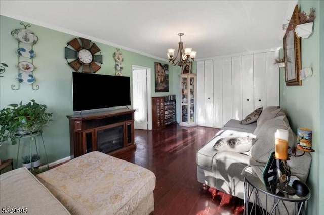 living room with dark hardwood / wood-style floors, crown molding, and a chandelier