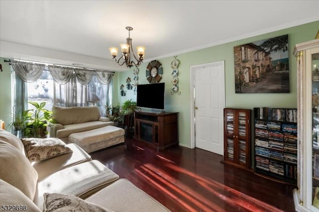 living room with dark hardwood / wood-style flooring, an inviting chandelier, and crown molding