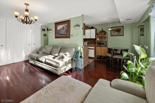 living room with a chandelier and dark wood-type flooring