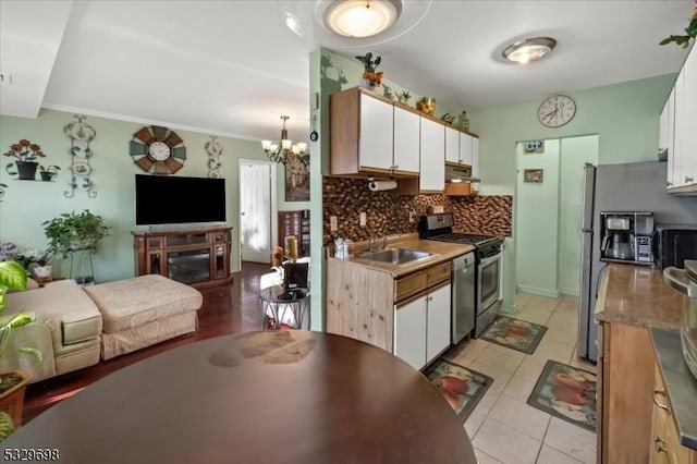 kitchen with white cabinets, decorative backsplash, sink, and appliances with stainless steel finishes