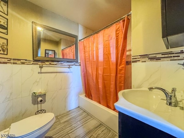 full bathroom featuring shower / bath combo with shower curtain, vanity, tile walls, and toilet