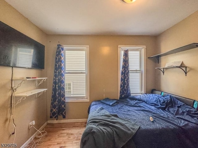 bedroom featuring hardwood / wood-style floors and multiple windows