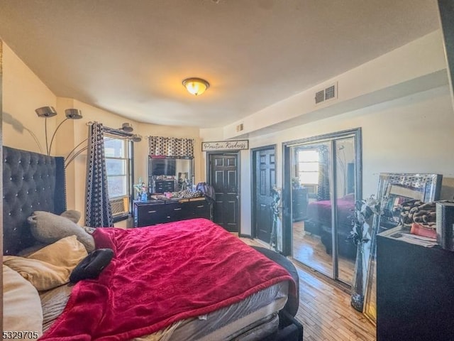 bedroom featuring wood-type flooring and multiple windows