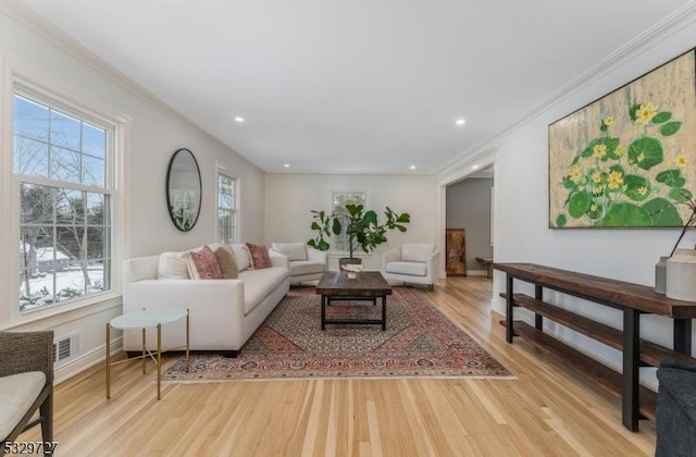 living room with crown molding and light hardwood / wood-style flooring