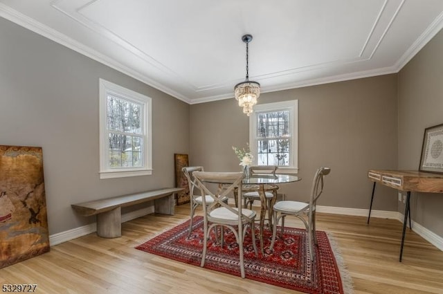 dining space with light hardwood / wood-style floors, a notable chandelier, and ornamental molding