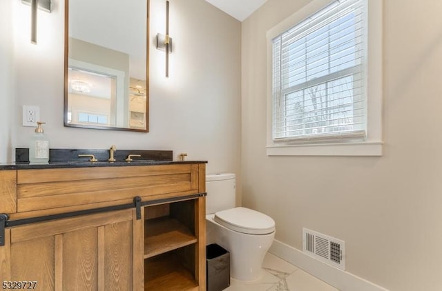 bathroom with a healthy amount of sunlight, toilet, and vanity