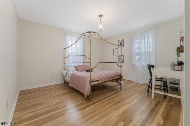 bedroom with multiple windows and light wood-type flooring