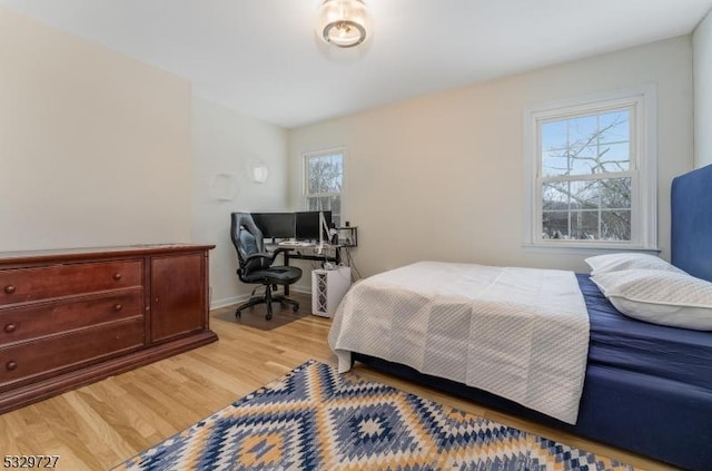 bedroom with multiple windows and light hardwood / wood-style flooring