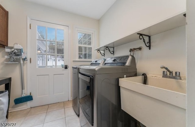 washroom with sink, independent washer and dryer, and light tile patterned floors