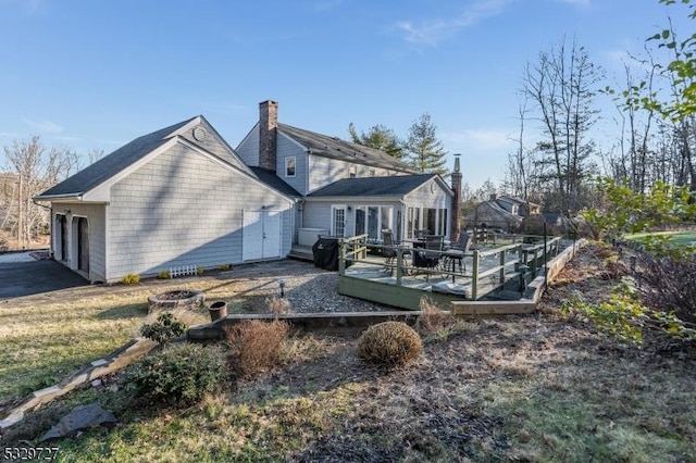 back of house with a fire pit and a wooden deck