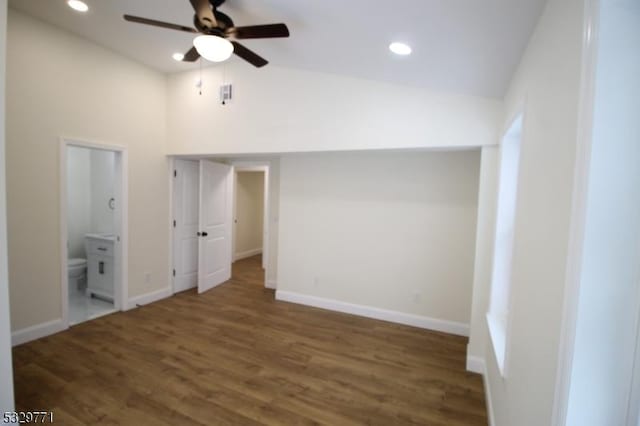 unfurnished bedroom featuring connected bathroom, dark hardwood / wood-style floors, ceiling fan, and lofted ceiling