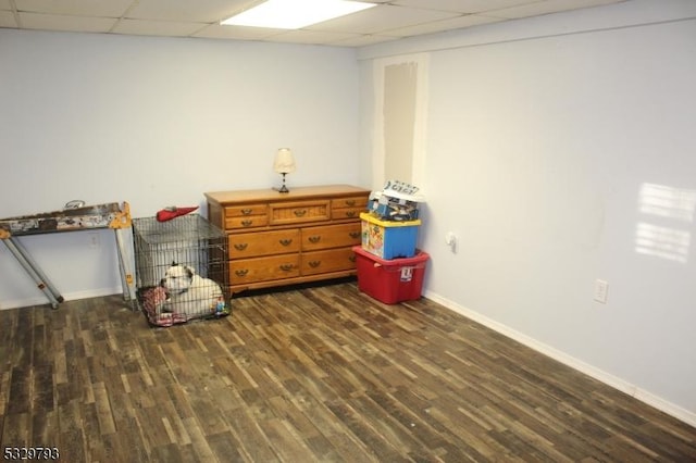 interior space with a paneled ceiling and dark wood-type flooring