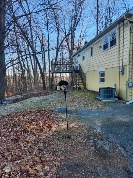 view of yard with a deck and central air condition unit