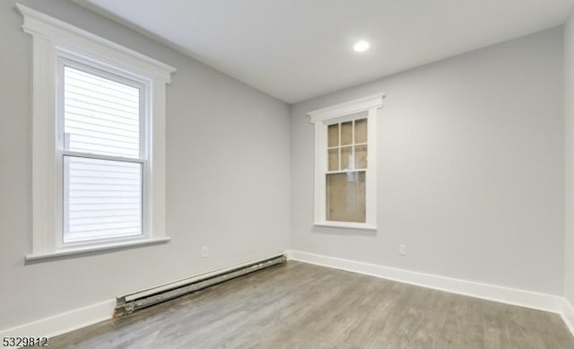 empty room featuring light hardwood / wood-style floors and baseboard heating