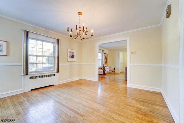 spare room featuring radiator, light hardwood / wood-style flooring, ornamental molding, and an inviting chandelier