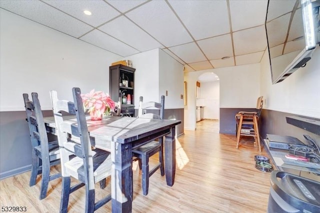 dining room with a paneled ceiling and light hardwood / wood-style flooring